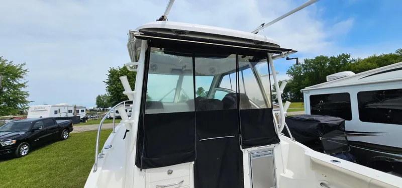 Slide: The Image of 2016 Boston Whaler 285 Conquest boat with covered cockpit, parked outdoors. - 17