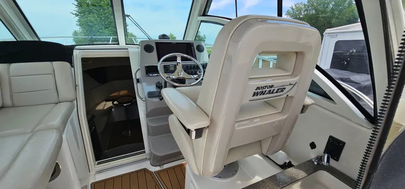 Slide: The Image of 2016 Boston Whaler 285 Conquest interior with helm and seating, showcasing luxury design. - 19