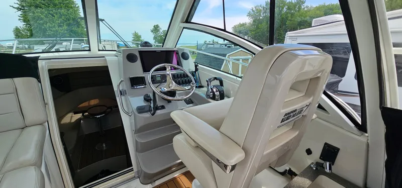 Slide: The Image of Interior of 2016 Boston Whaler 285 Conquest boat, featuring helm and captain's chair. - 21