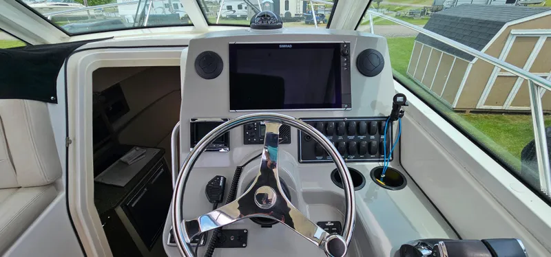 Slide: The Image of 2016 Boston Whaler 285 Conquest helm with steering wheel and navigation display. - 26