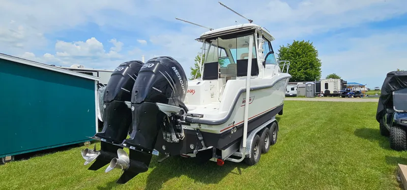 Slide: The Image of 2016 Boston Whaler 285 Conquest boat with dual outboard motors on a trailer. - 3