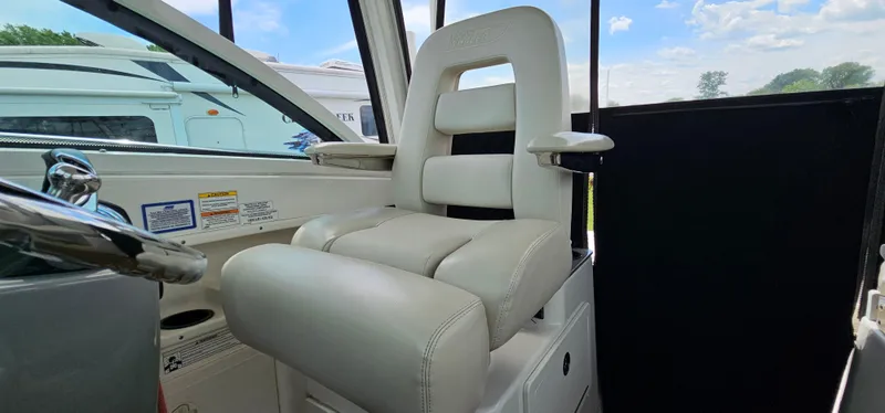 Slide: The Image of Captain's chair on 2016 Boston Whaler 285 Conquest boat, featuring plush white upholstery. - 35
