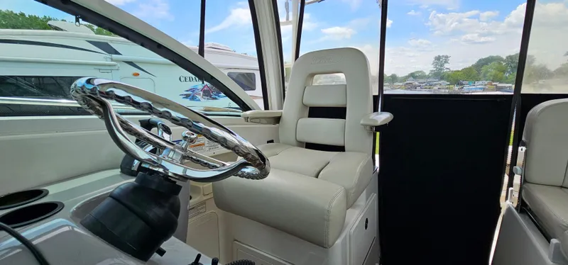 Slide: The Image of Interior view of 2016 Boston Whaler 285 Conquest boat with steering wheel and captain's chair. - 36