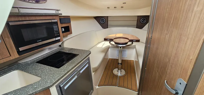 Slide: The Image of 2016 Boston Whaler 285 Conquest cabin interior with kitchenette and seating area. - 37