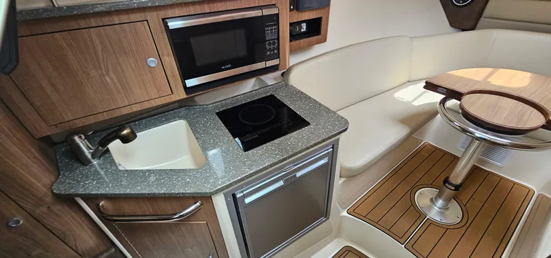 Slide: The Image of 2016 Boston Whaler 285 Conquest interior with kitchenette and seating area. - 39