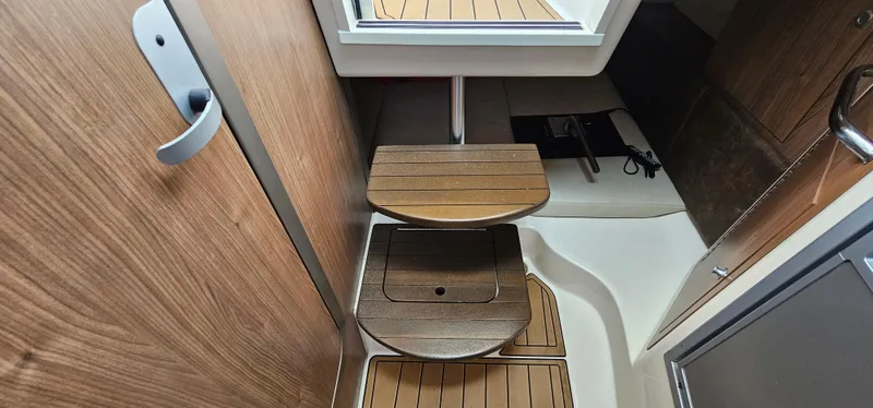 Slide: The Image of 2016 Boston Whaler 285 Conquest cabin interior with wooden steps and modern design. - 48