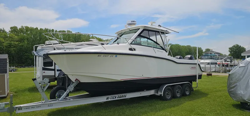 Slide: The Image of 2016 Boston Whaler 285 Conquest boat on a trailer, parked on grass. - 6