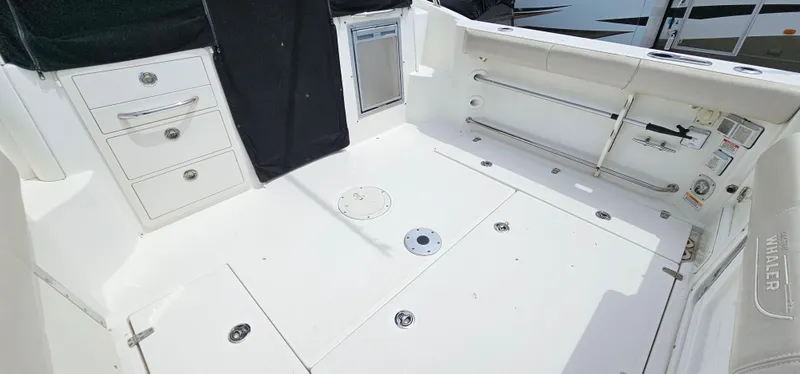 Slide: The Image of 2016 Boston Whaler 285 Conquest boat deck with storage compartments and seating area. - 8