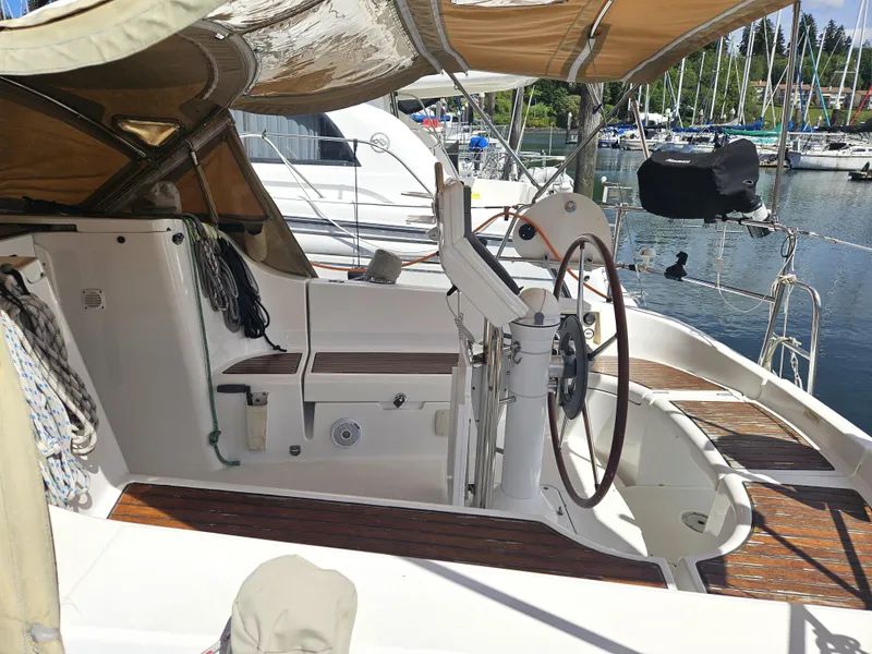 Slide: The Image of 2008 Beneteau 323 sailboat cockpit with steering wheel, docked at marina. - 10
