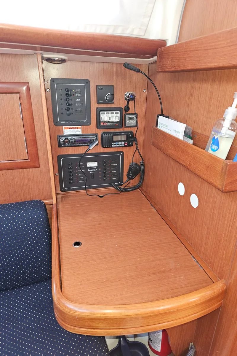 Slide: The Image of Navigation station on a 2008 Beneteau 323 sailboat with control panels and communication equipment. - 15