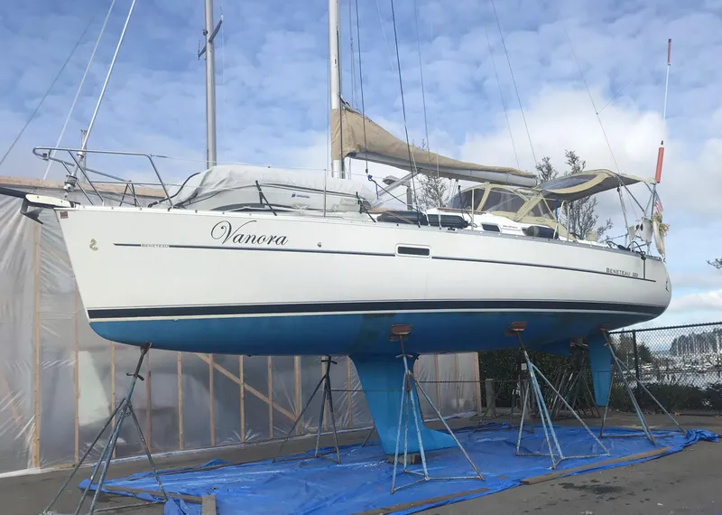 Slide: The Image of 2008 Beneteau 323 sailboat on stands, white hull, blue keel, outdoor storage. - 2