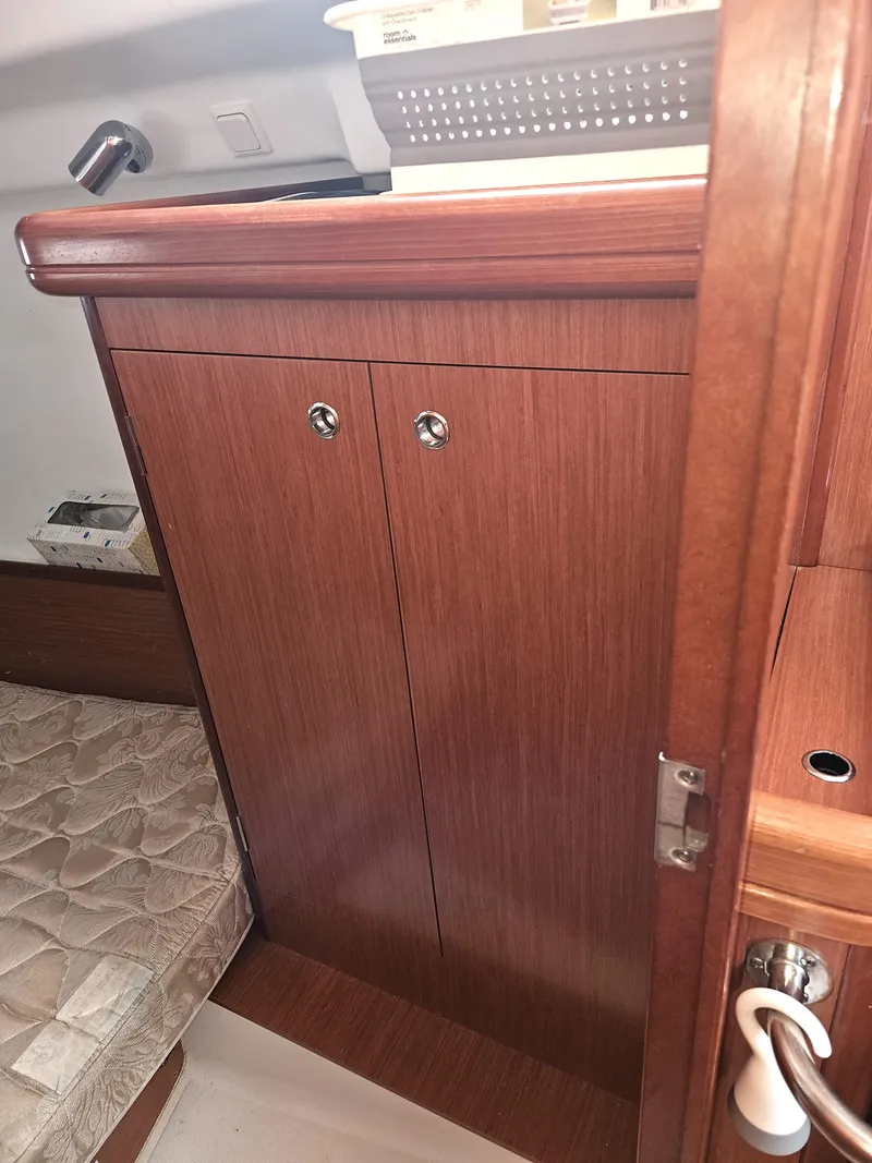 Slide: The Image of Interior of 2008 Beneteau 323 sailboat with wooden cabinetry and cozy sleeping area. - 21