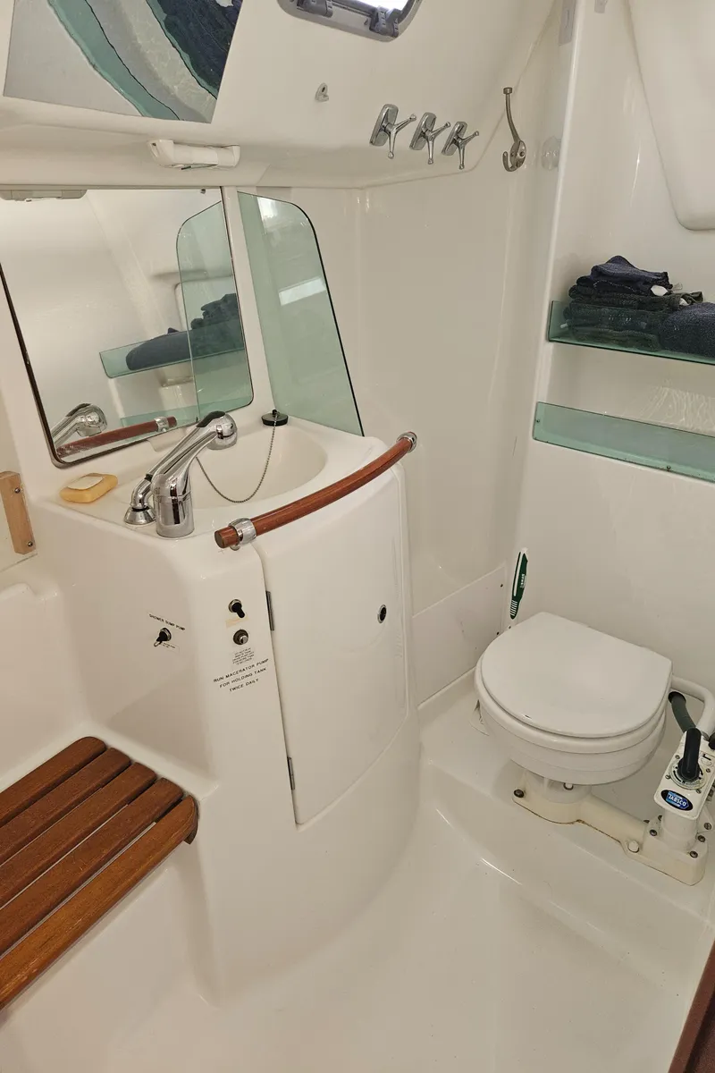 Slide: The Image of 2008 Beneteau 323 yacht bathroom with sink, toilet, and wooden seat. - 24