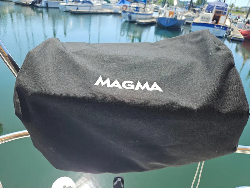 Slide: The Image of Black Magma grill cover on Beneteau 323 sailboat, marina background. - 30