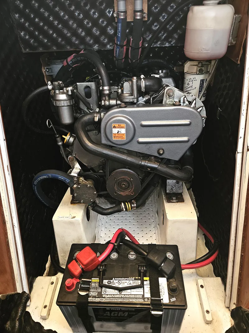 Slide: The Image of Engine compartment of a 2008 Beneteau 323 sailboat, featuring a well-maintained motor and battery. - 32
