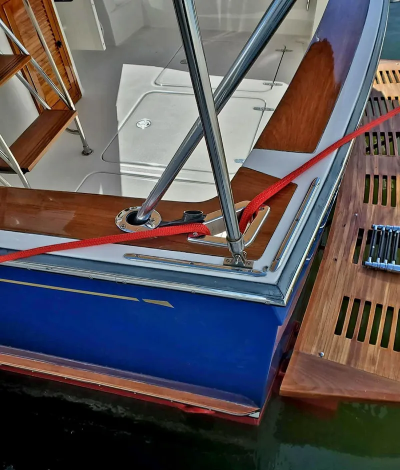Slide: The Image of 2004 Sabreline 36 Flybridge Fast Trawler, blue hull, docked with red rope. - 13