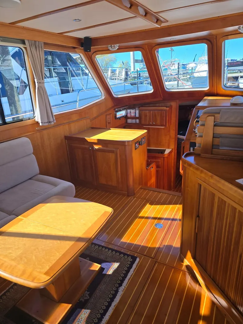 Slide: The Image of 2004 Sabreline 36 Flybridge Fast Trawler interior with wooden furnishings and seating area. - 18