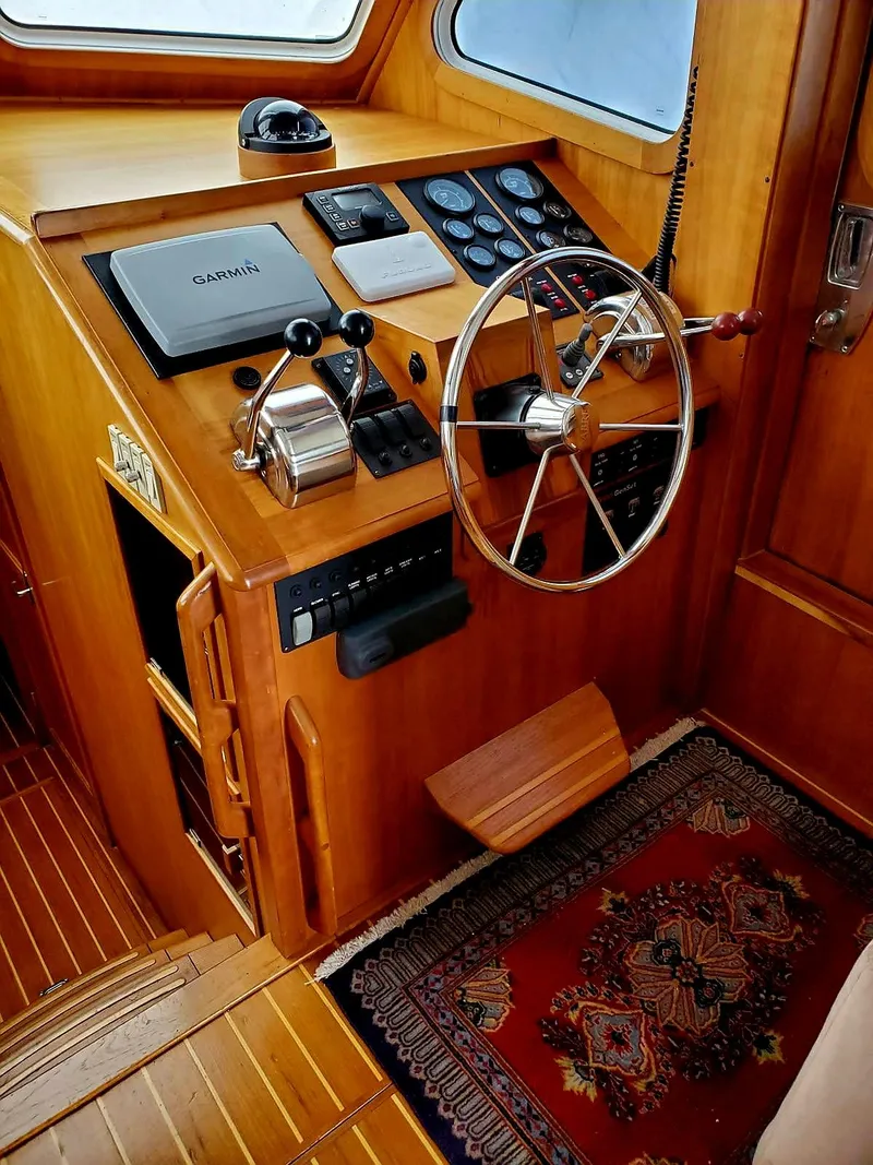 Slide: The Image of 2004 Sabreline 36 Flybridge Fast Trawler helm with wooden finish and navigation equipment. - 20