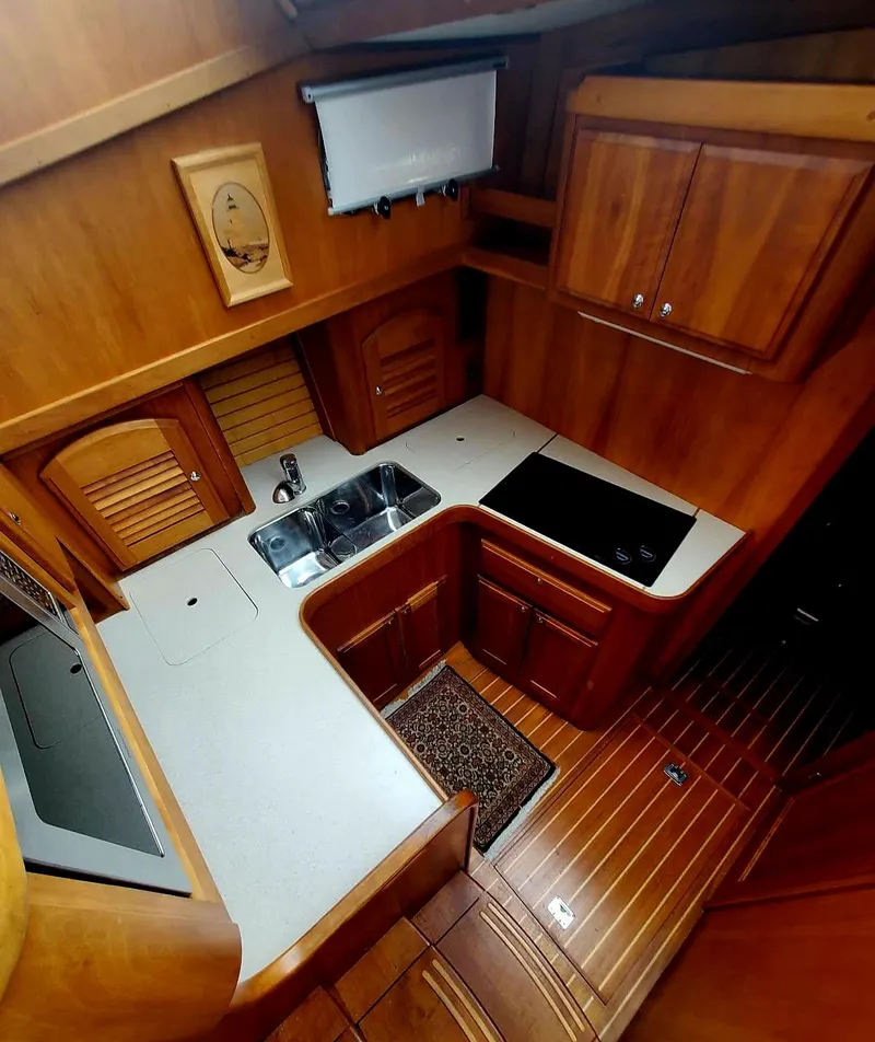 Slide: The Image of 2004 Sabreline 36 Flybridge Fast Trawler kitchen with wood cabinetry and modern appliances. - 22