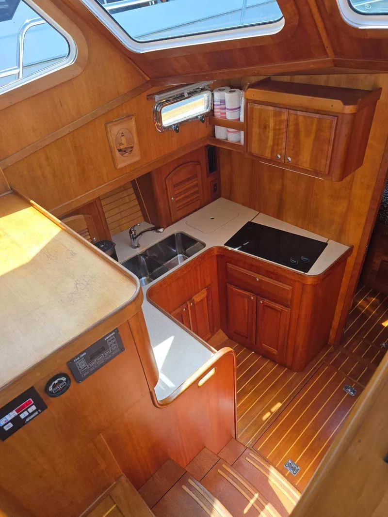 Slide: The Image of 2004 Sabreline 36 Flybridge Fast Trawler kitchen with wood cabinetry and modern appliances. - 23