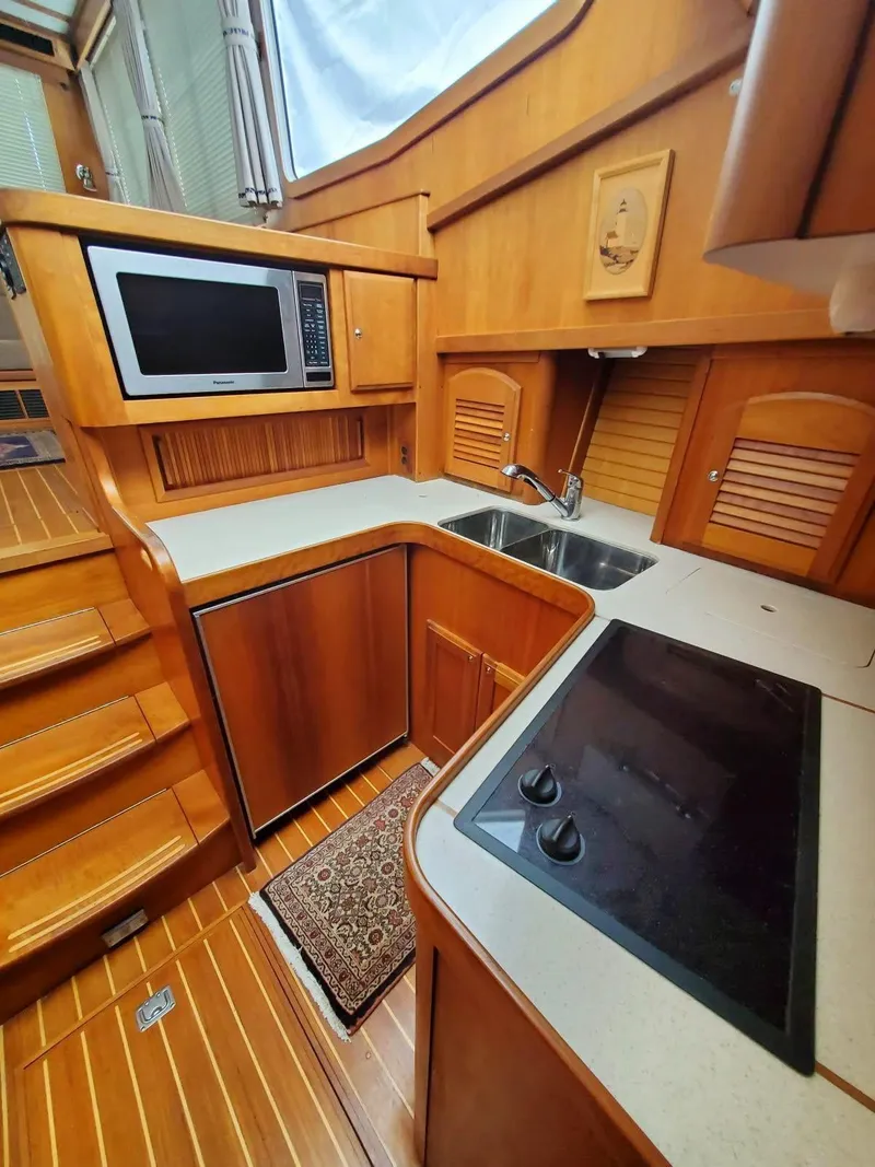 Slide: The Image of 2004 Sabreline 36 Flybridge Fast Trawler kitchen with wood cabinetry and modern appliances. - 24