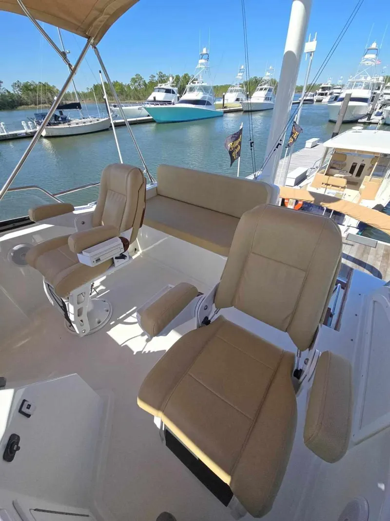 Slide: The Image of 2004 Sabreline 36 Flybridge Fast Trawler with beige seating, docked at a marina. - 36