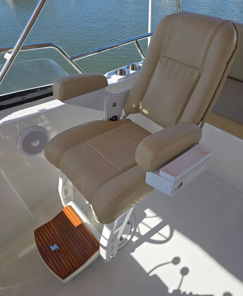 Slide: The Image of Captain's chair on 2004 Sabreline 36 Flybridge Fast Trawler, beige upholstery, wooden footrest. - 40