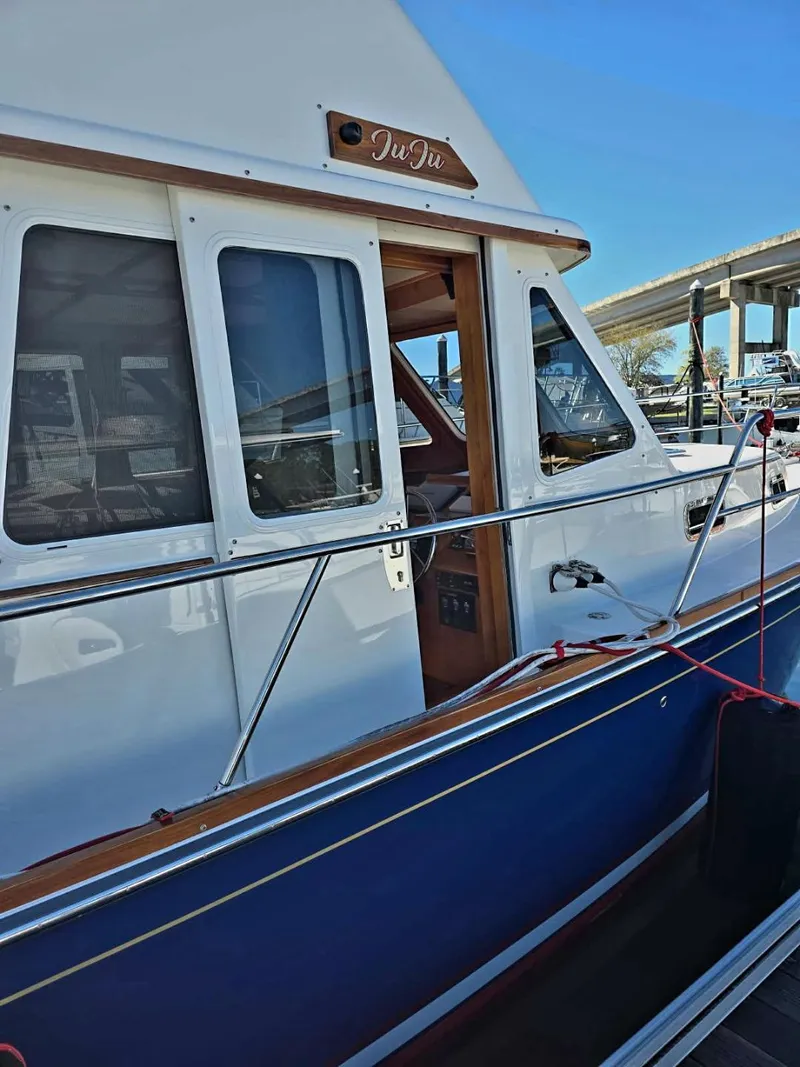 Slide: The Image of 2004 Sabreline 36 Flybridge Fast Trawler, docked with blue hull and white cabin. - 9