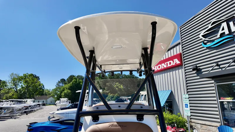 Slide: The Image of 2025 Pioneer 202 Islander boat with T-top, displayed outdoors near dealership. - 10