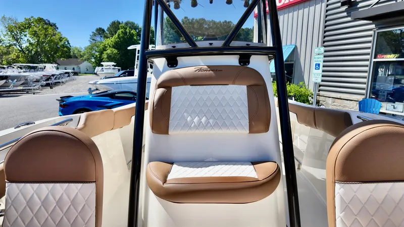 Slide: The Image of 2025 Pioneer 202 Islander boat interior with tan and white seating, docked outdoors. - 11