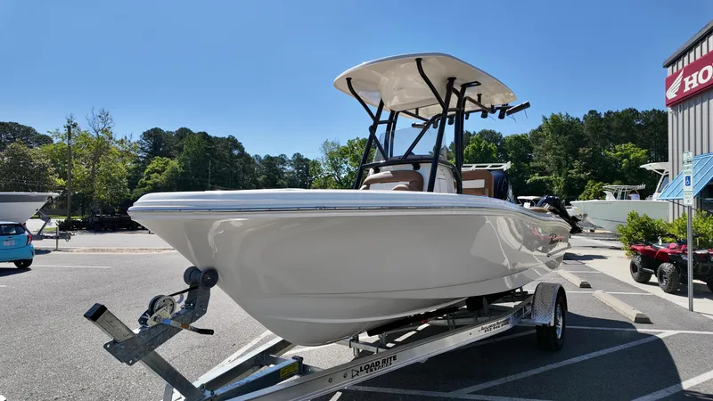 Slide: The Image of 2025 Pioneer 202 Islander boat on trailer, parked outdoors under clear blue sky. - 14