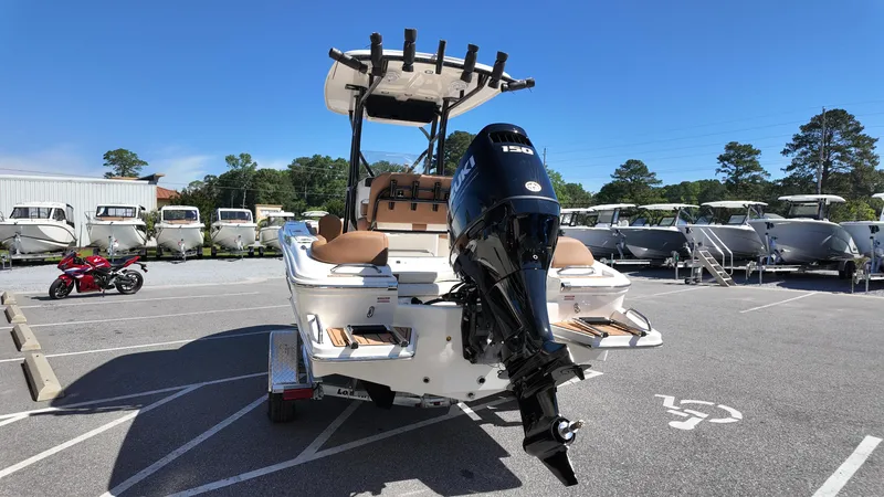 Slide: The Image of 2025 Pioneer 202 Islander boat with outboard motor in a parking lot. - 16