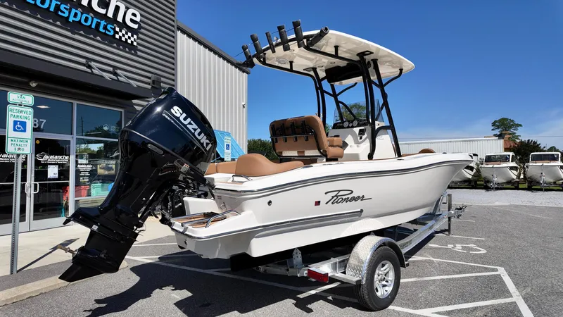Slide: The Image of 2025 Pioneer 202 Islander boat with Suzuki engine on trailer, parked outside dealership. - 17