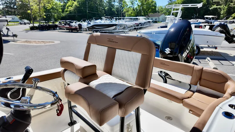 Slide: The Image of 2025 Pioneer 202 Islander boat interior with tan and white seating, steering wheel, and motor. - 8