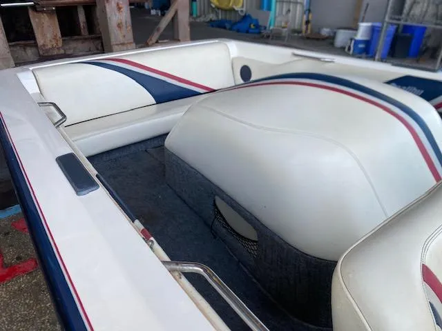 Slide: The Image of 1998 Malibu Response boat interior with white and blue upholstery, featuring red accents. - 11