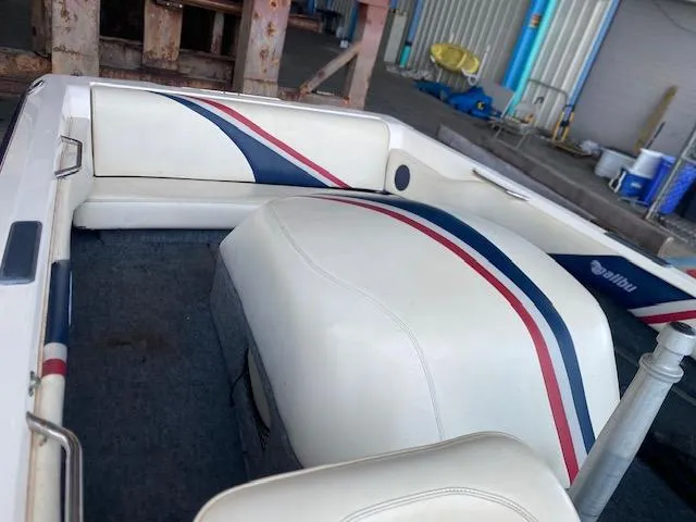 Slide: The Image of 1998 Malibu Response boat interior with white, red, and blue upholstery in a garage setting. - 12