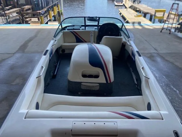 Slide: The Image of 1998 Malibu Response boat interior with striped upholstery, docked by the water. - 17