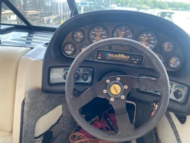 Slide: The Image of 1998 Malibu Response boat dashboard with steering wheel and instrument panel. - 18