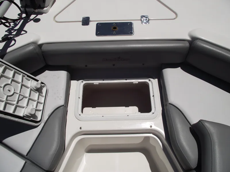 Slide: The Image of 2022 NauticStar 191 Hybrid boat interior with open storage compartment and cushioned seating. - 13