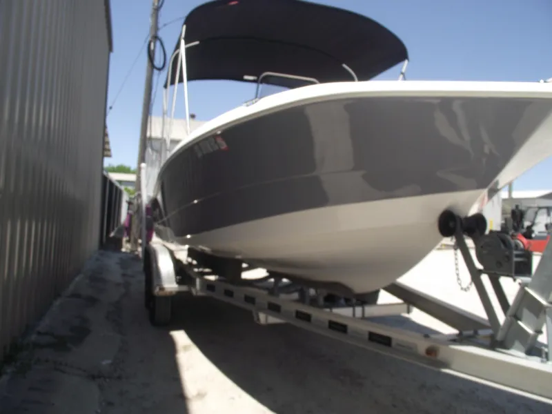 Slide: The Image of 2022 NauticStar 191 Hybrid boat on trailer, parked outdoors under a clear sky. - 2