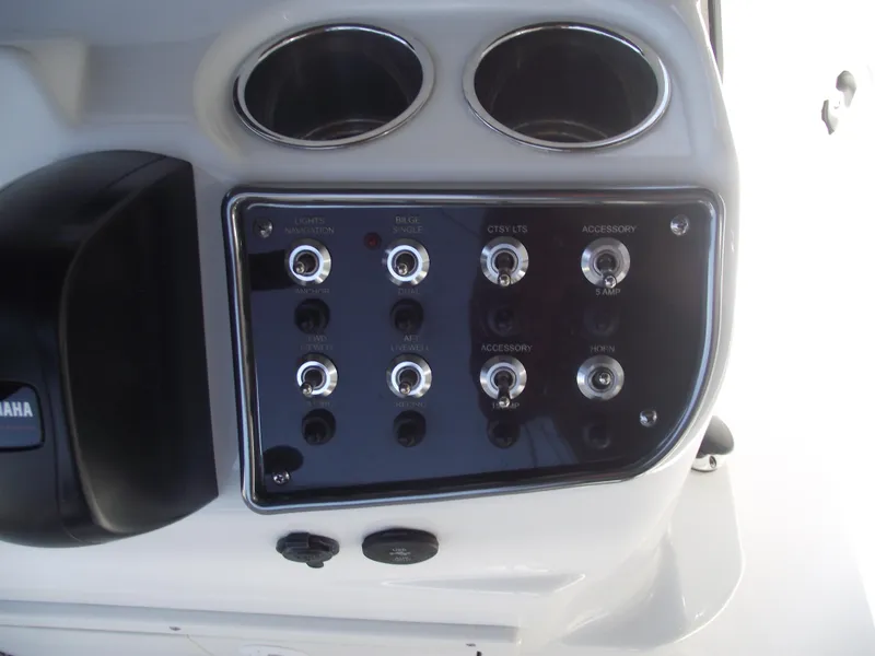Slide: The Image of Control panel of 2022 NauticStar 191 Hybrid boat with switches and cup holders. - 25