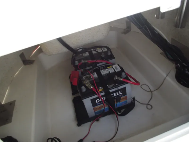 Slide: The Image of 2022 NauticStar 191 Hybrid boat battery compartment with dual batteries and wiring. - 29