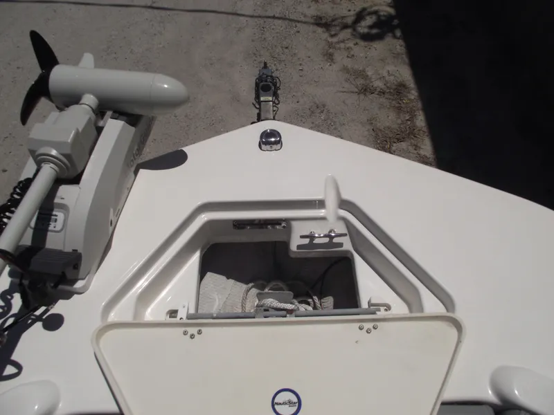 Slide: The Image of 2022 NauticStar 191 Hybrid boat bow with open storage compartment and trolling motor. - 7