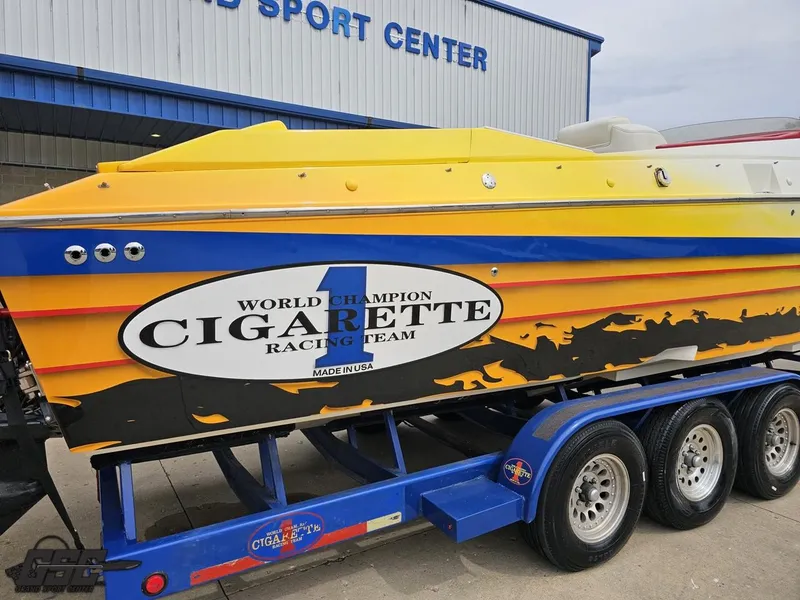 Slide: The Image of 2001 Cigarette 42 Tiger powerboat on trailer, vibrant yellow and black design, at sports center. - 11