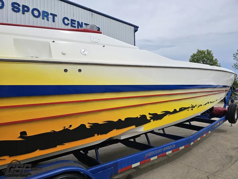 Slide: The Image of 2001 Cigarette 42 Tiger boat with vibrant yellow and blue design on trailer. - 13