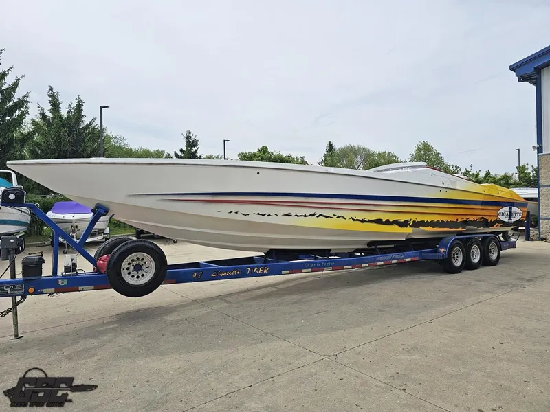 Slide: The Image of 2001 Cigarette 42 Tiger speedboat on trailer, featuring vibrant yellow and orange graphics. - 22