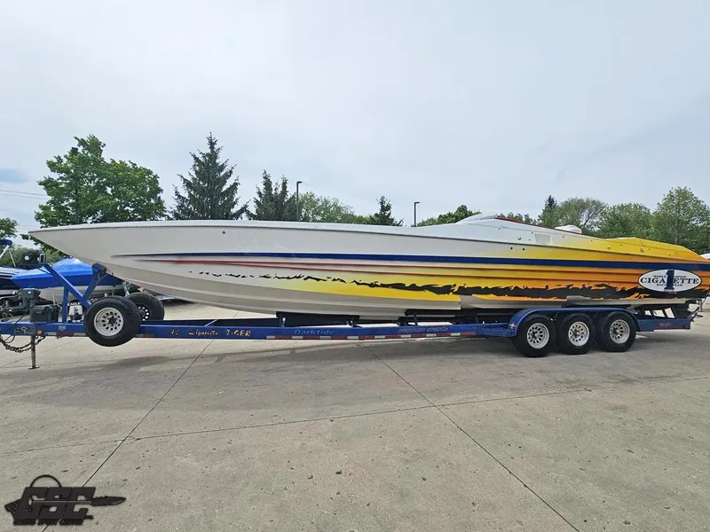 Slide: The Image of 2001 Cigarette 42 Tiger speedboat on trailer, featuring vibrant yellow and orange graphics. - 23
