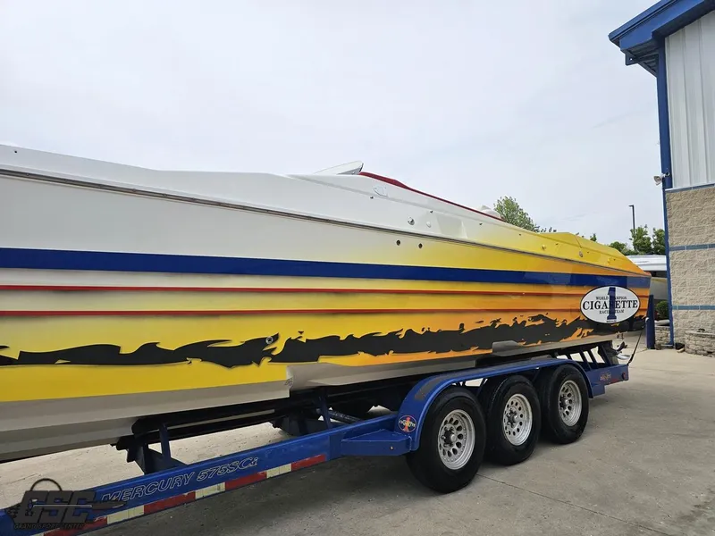 Slide: The Image of 2001 Cigarette 42 Tiger speedboat on trailer, featuring vibrant yellow and blue design. - 25