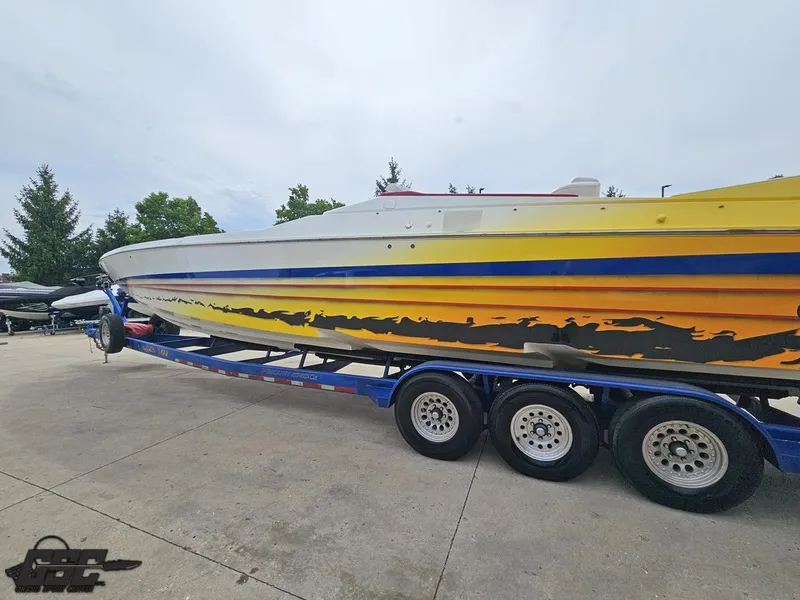 Slide: The Image of 2001 Cigarette 42 Tiger speedboat with vibrant yellow and blue design on a trailer. - 28
