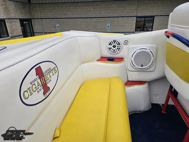 Slide: The Image of Interior of 2001 Cigarette 42 Tiger boat with yellow and white seating, branded logo, and speakers. - 49